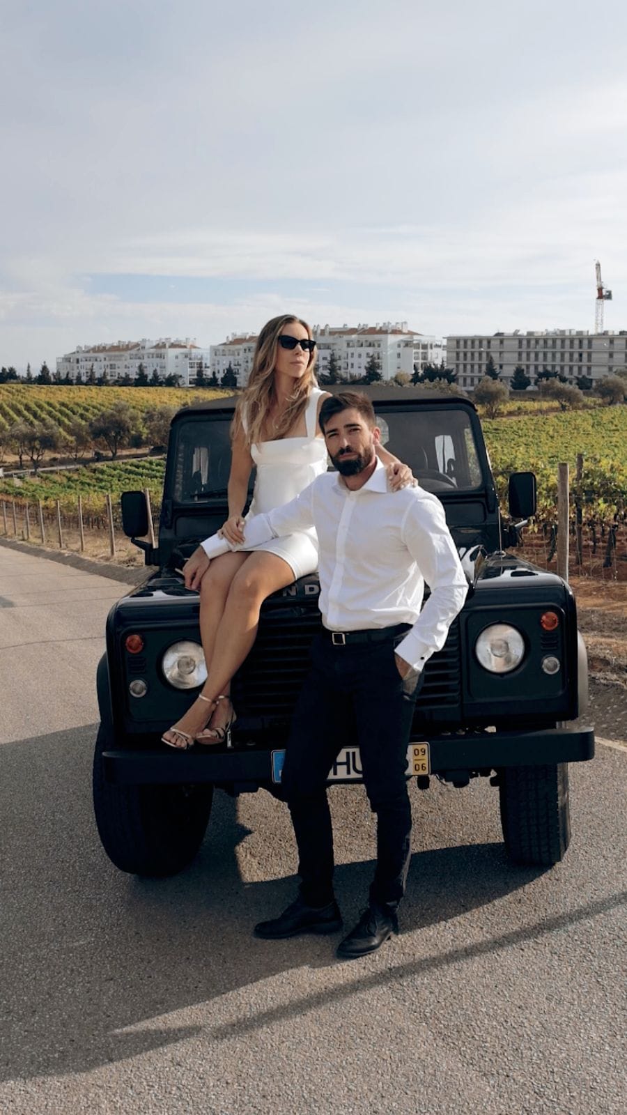 Casal elegante posando em carro clássico durante sessão de vídeo de casamento cinematográfico em Cascais Lisboa